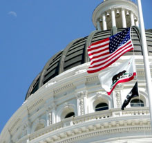 US and California flags flying at Capitol's dome